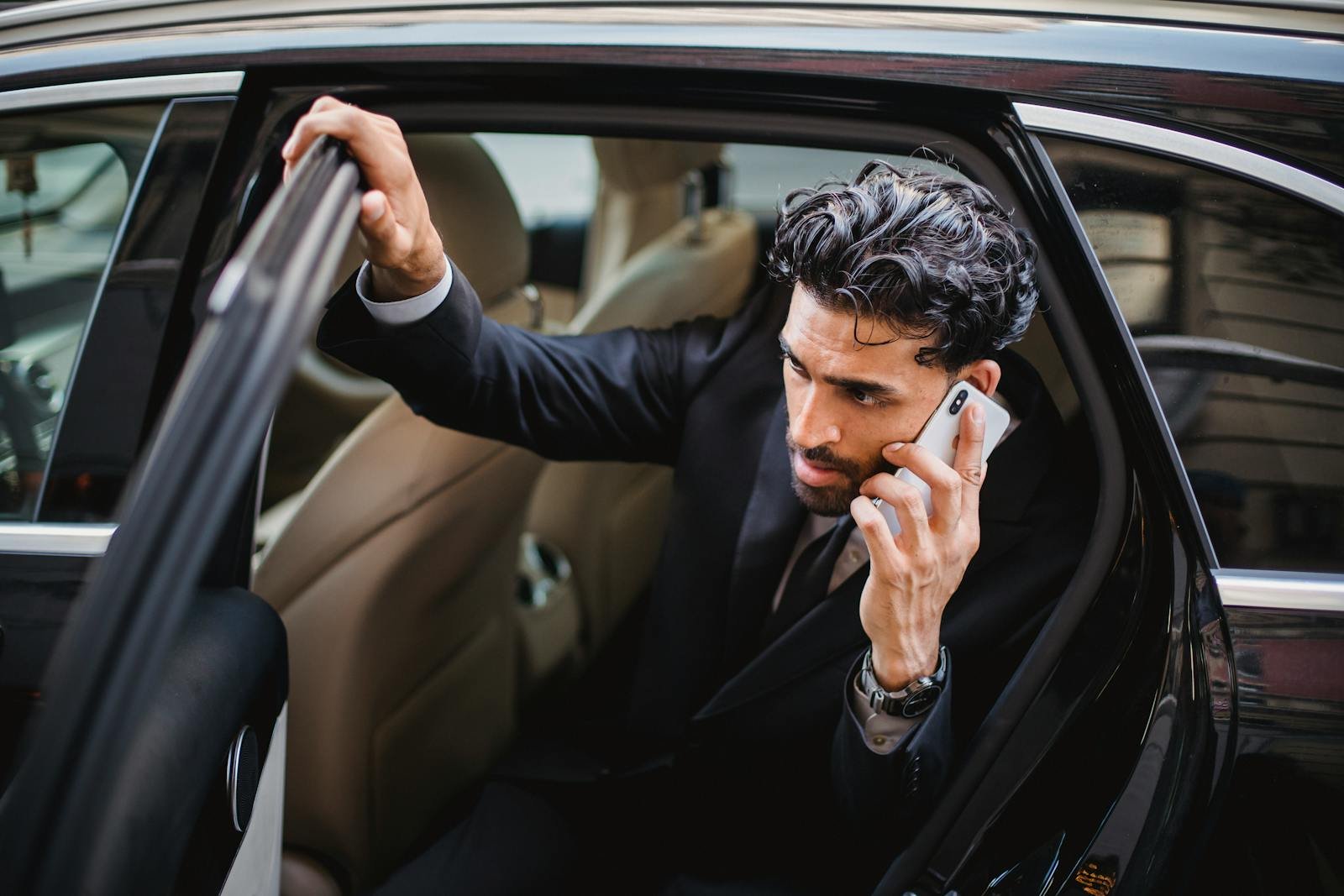 London Airport private transfer, luxury vehicle during a phone call, emphasizing a busy lifestyle.